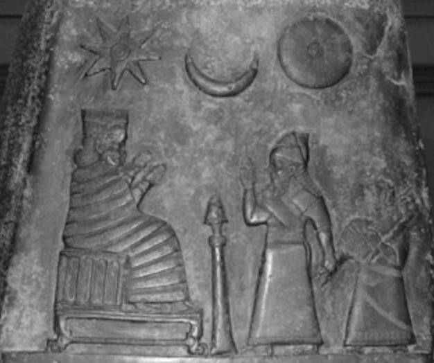 Relieve en piedra que representa figuras humanas con símbolos astronómicos como una estrella, una luna y un disco solar.