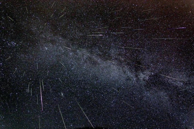 Cielo nocturno lleno de estrellas con meteoros brillando, representando la lluvia de estrellas Perseidas.